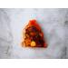 Orange potpourri bag from Irish Twins Potpourri with dried flowers and wood chips, labeled ‘Handmade with love’ on a cement gray background.